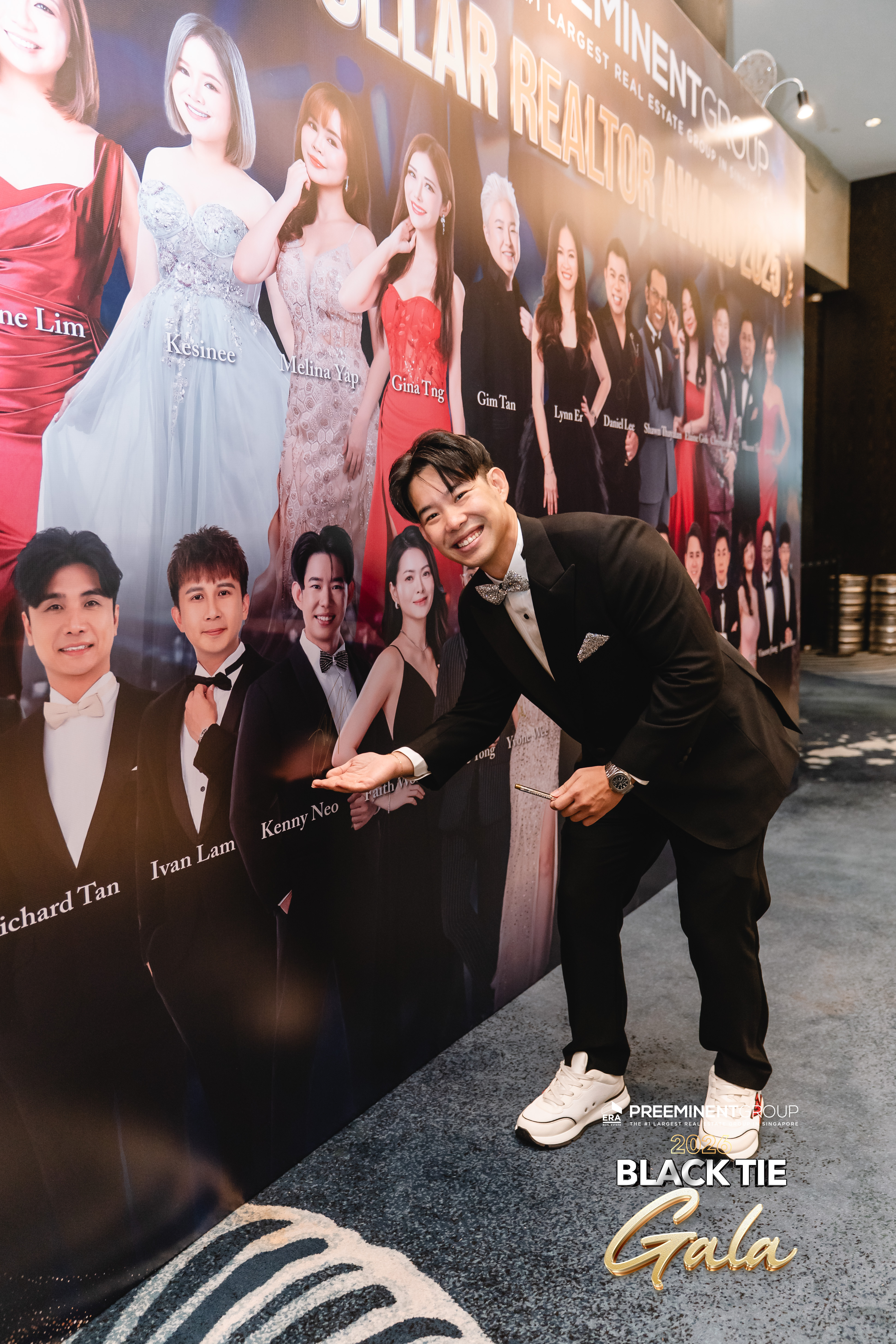 Kenny Neo pointing at his name on the Black Tie Gala banner 2026
